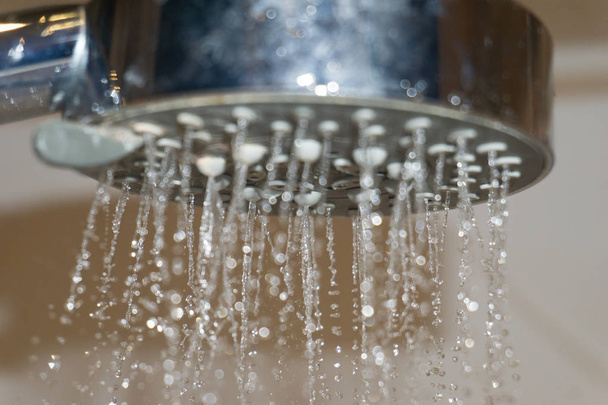 Jet d'eau d'une pomme de douche dans la salle de bain. - Photo, image