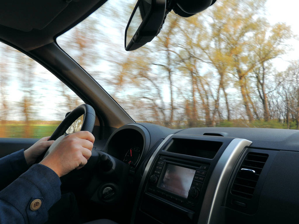 Optimale positie van mans handen op het stuurwiel in snel bewegend voertuig - Foto, afbeelding