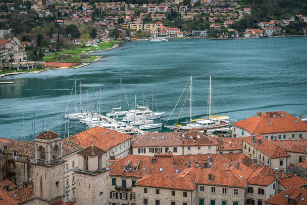 Kotor, Montenegro - April 2018 : Houses and marina in Kotor town, as seen from the trail to the fortress above town - Photo, Image