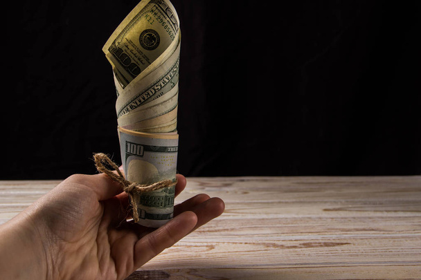 Siyah bir arka plan üzerinde a yelpaze-in dolar tutan eller - Fotoğraf, Görsel