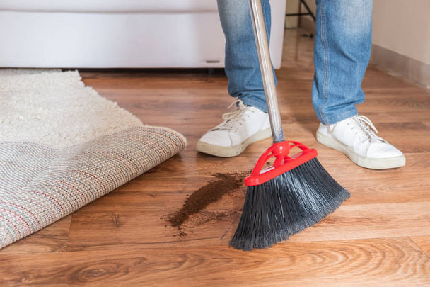 Primo piano pulizia uomo spazzare pavimento in legno con scopa
 - Foto, immagini