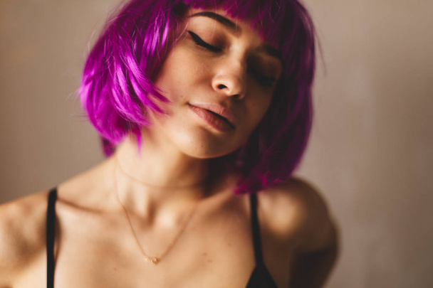 Close up portrait of young woman with pink bob cut and stylish makeup. She look happy, smiling and sexy - Photo, Image