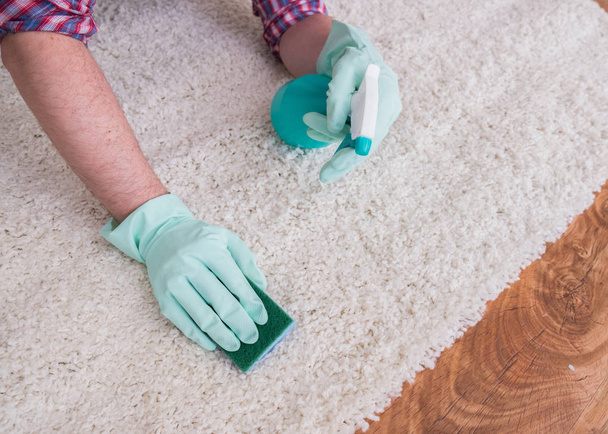 Essuyer le tapis blanc en bois et le sol avec une éponge
 - Photo, image