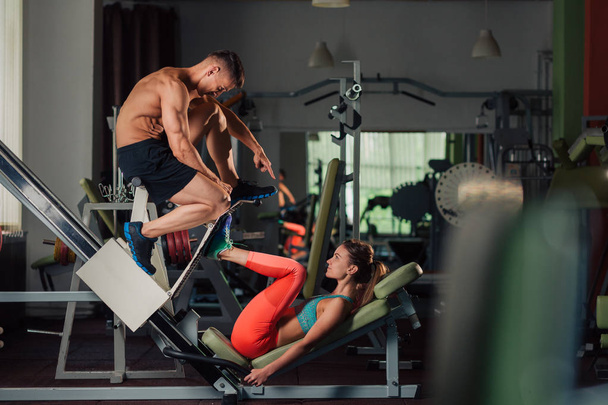 Jeune couple en forme faisant une séance d'entraînement de presse jambes ensemble
 - Photo, image
