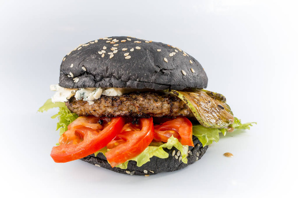 tasty burger with cheese and black bun on a white background - Photo, image