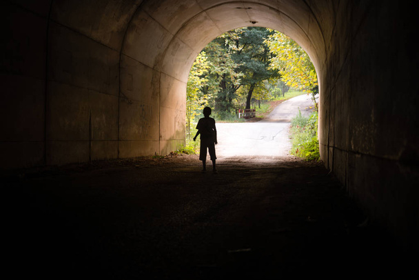 Chłopak sam, wprowadzając ciemny tunel. - Zdjęcie, obraz