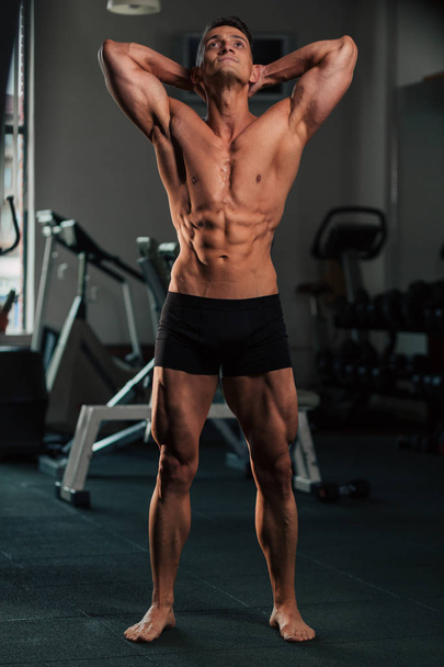 Young fit man doing bodybuilding competition poses - Fotó, kép