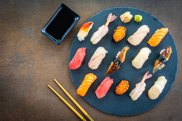 Nigiri sushi set with salmon tuna fish shrimp camarão enguia shell and other sashimi on black arlate - Japonês food style
 - Foto, Imagem