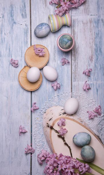 Happy Easter card template with pink Hyacinth flowers and colored eggs on wooden background  - Photo, image