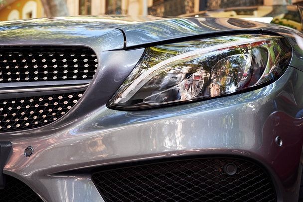 Close-up of front headlights and hood of a new dark greay modern car. Details of luxury cars. - Valokuva, kuva
