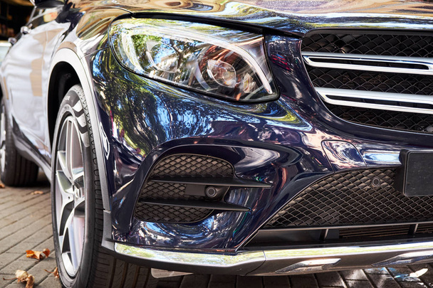 Close-up van de voorzijde koplampen en de kap van een nieuwe zwarte moderne auto. Details van luxe auto 's. - Foto, afbeelding