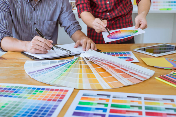 Ομάδα δημιουργικό γραφίστα συνάντηση εργασίας στο νέο έργο, επιλέξτε επιλογή χρώματος και σχεδίασης γραφικών tablet με την εργασία εργαλεία και αξεσουάρ. - Φωτογραφία, εικόνα