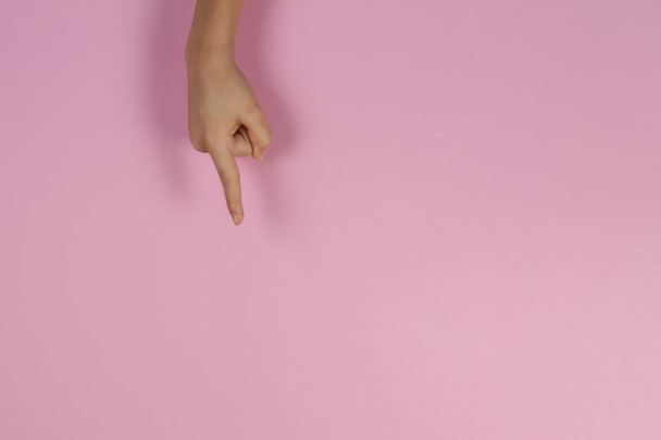 Kid hand pointing on pastel pink background - Fotó, kép