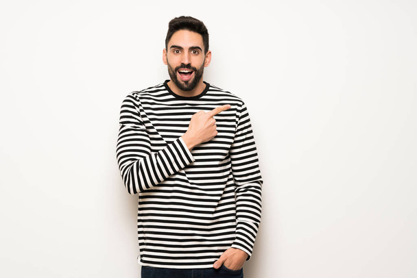 handsome man with striped shirt pointing to the side to present a product - Photo, Image