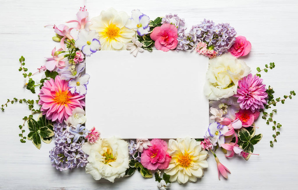 Festive flower composition with greeting card on the white wooden background. Overhead view - Foto, Bild