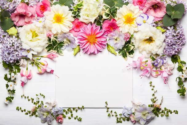 Festliche Blumenkomposition mit Grußkarte auf weißem Holzgrund. Blick über den Kopf - Foto, Bild