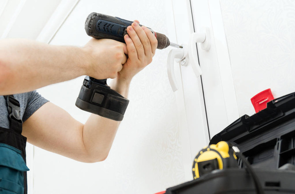Professional handyman fixing window handle at home. - Photo, Image