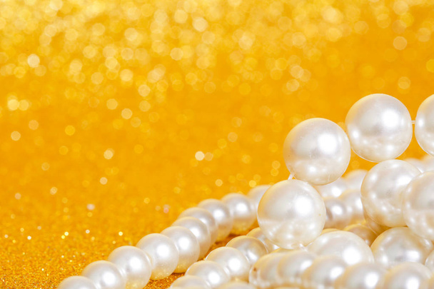 Montón de perlas sobre fondo de navidad de oro
 - Foto, imagen