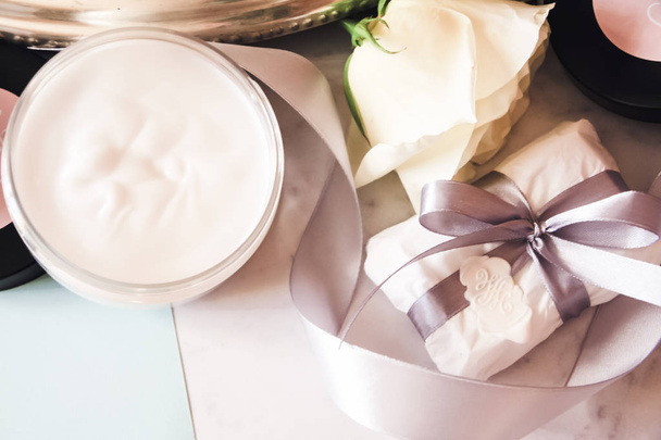 cosmetics, rose, sea salt, coconut oil, gray ribbon, white wax, gift with bow - Φωτογραφία, εικόνα