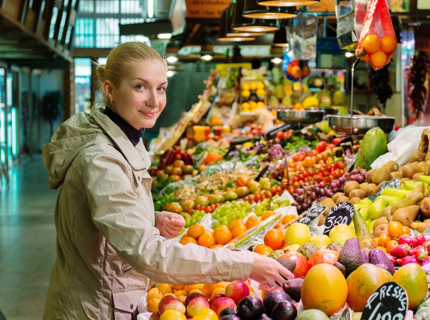 Молода весела блондинка вибирає свіжі фрукти на ринку
 - Фото, зображення