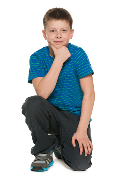 Pensive poika sininen paita istuu lattialla
 - Valokuva, kuva
