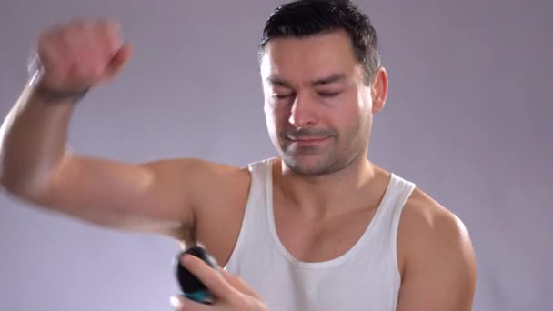 Gente hispana y belleza masculina. Hombre metrosexual confiado usando desodorante en aerosol en la piel de las axilas
 - Imágenes, Vídeo