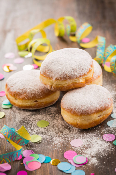 Krapfen, Berliner or  donuts with streamers and confetti. Colorful carnival or birthday image - Photo, Image