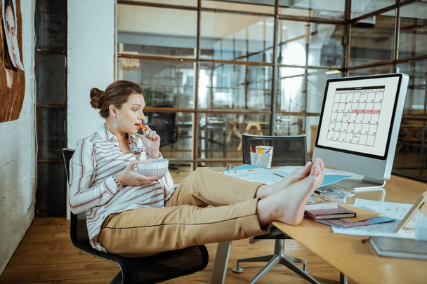 Pregnant employed woman enjoying her lunch break in office - Photo, image