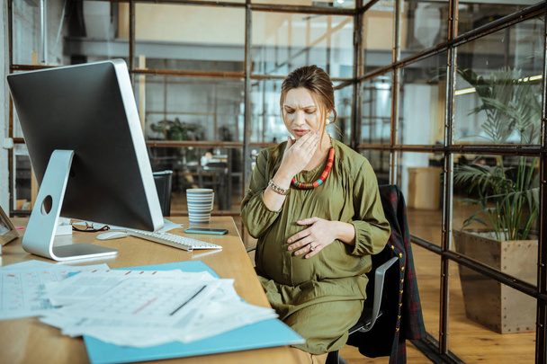 Embarazada mujer de negocios se siente ansiosa mientras tiene dolor de muelas
 - Foto, Imagen