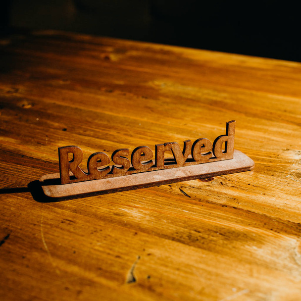 Placa de madera reservada en mesa de madera
 - Foto, Imagen