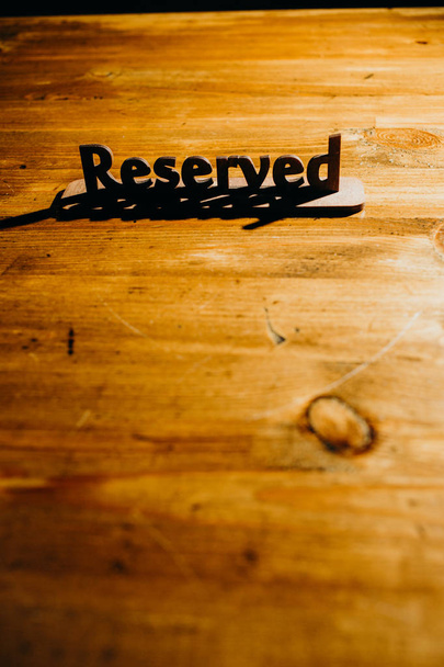 Wooden plate reserved on wooden table - Foto, Bild