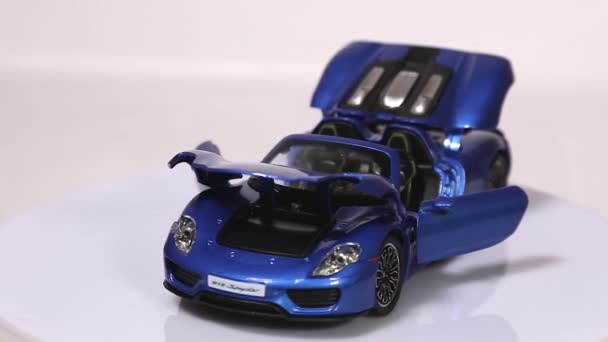 BERLIN, GERMANY - JANUARY. 2019: Blue Porsche 918 Spyder scale model sports car with opened doors and hood is rotating isolated on white background. - Záběry, video