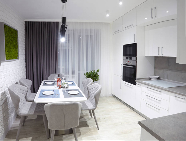 灰色の椅子と白いキッチン インテリアと白い板メガネと新しい豪華な家の壁に苔に役立ったテーブル ライトします。 - 写真・画像