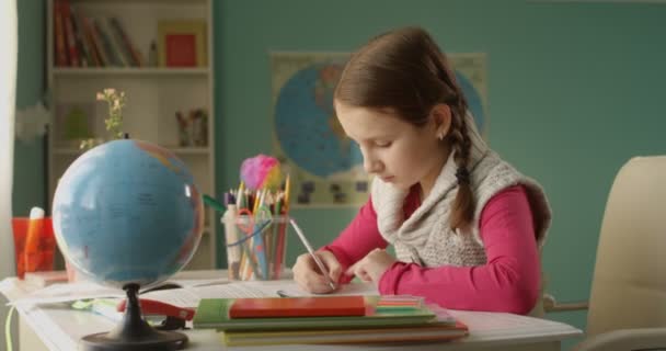 Little School Girl is Doing Homework at the Table at Home on Sunny Day - Felvétel, videó