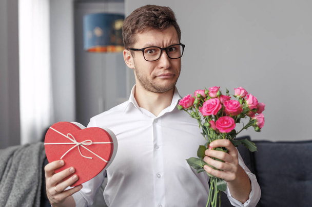 Mężczyzna niezadowolony z Valentines Day obecny i kwiaty - Zdjęcie, obraz
