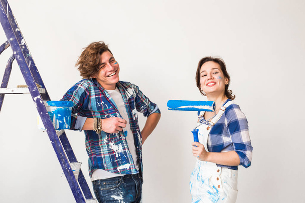 Ristrutturazione, riparazione e concetto di persone - Giovani coppie sposate che dipingono pareti nella loro nuova casa
. - Foto, immagini