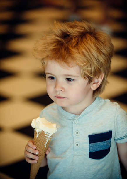 Ребенок с мороженым. Красивый мальчик ест мороженое летом. Сладкий вкусный десерт для детей. Детский дантист
 - Фото, изображение