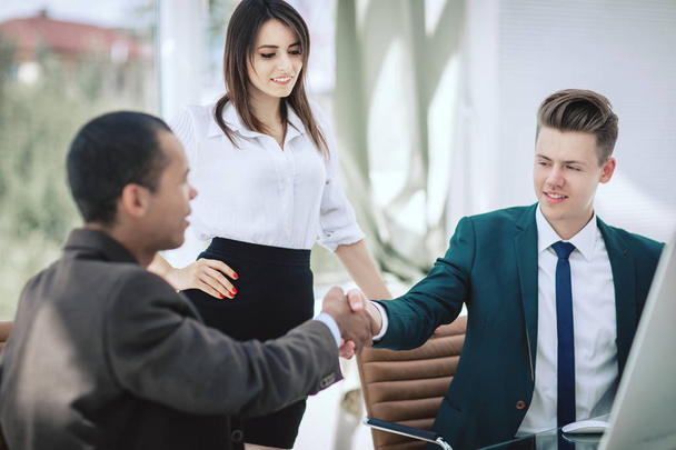 handshake of business partners sitting at a Desk - Photo, Image