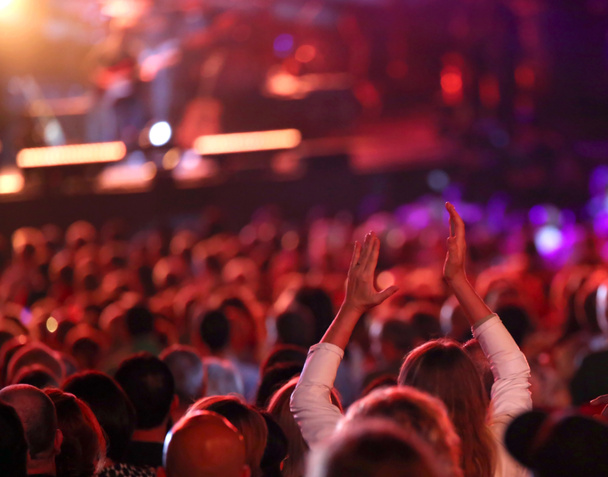 κορίτσι με τα χέρια επάνω σε ζωντανή συναυλία με πολλούς ανθρώπους - Φωτογραφία, εικόνα