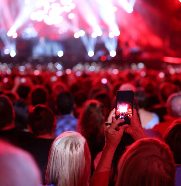 ロックのライブ中に写真を撮影しながらスマート フォンを持つ人々 - 写真・画像