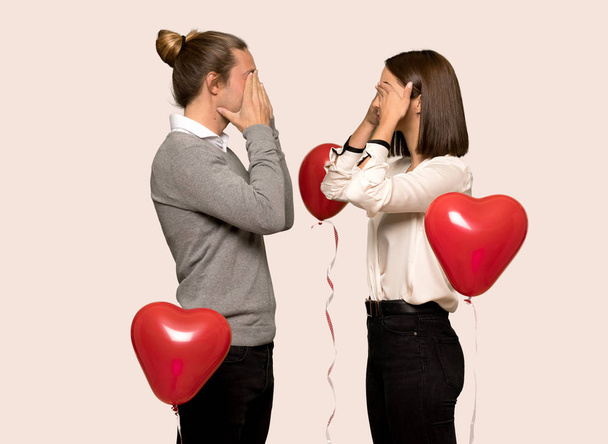 Couple in valentine day covering eyes by hands. Surprised to see what is ahead over isolated background - Фото, изображение