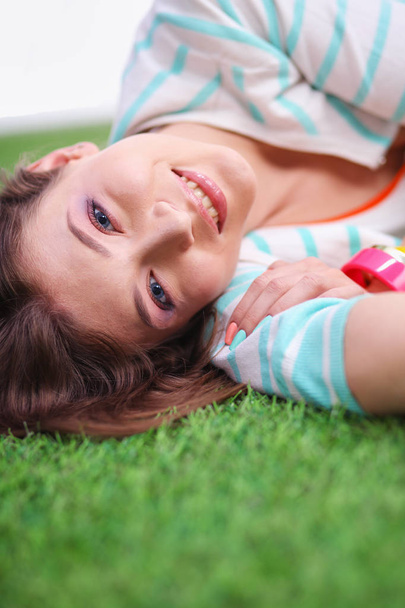 Beautiful young woman lying on the green grass - Photo, image