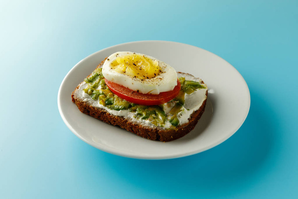 sandwich with avocado salad on white plate blue background Avocado and mayonnaise with egg and paprika. - Foto, Imagem