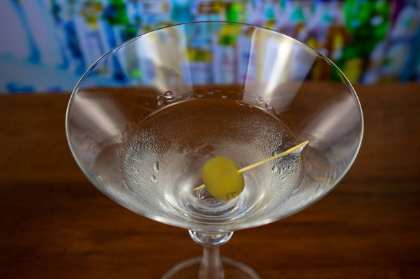 Kuiva martini cocktail oliivi hammastikulla
 - Valokuva, kuva