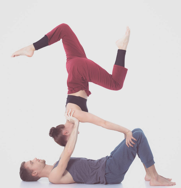 Young athletic couple practicing acroyoga. Balancing in pair. - Foto, Bild