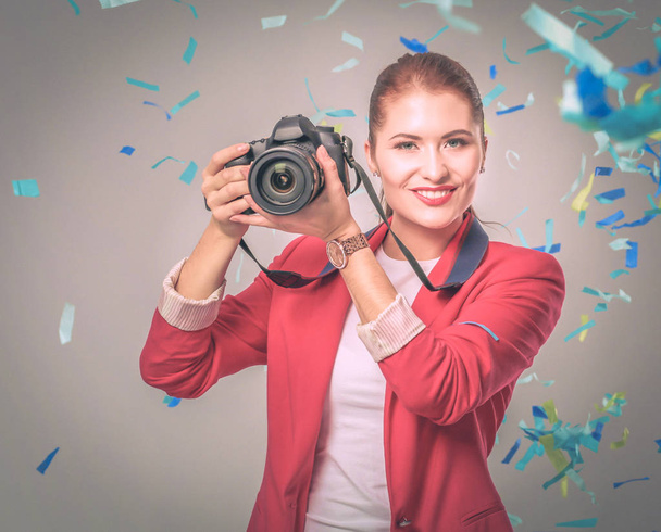 Beautiful happy woman with camera at celebration party with confetti . Birthday or New Year eve celebrating concept - Fotó, kép
