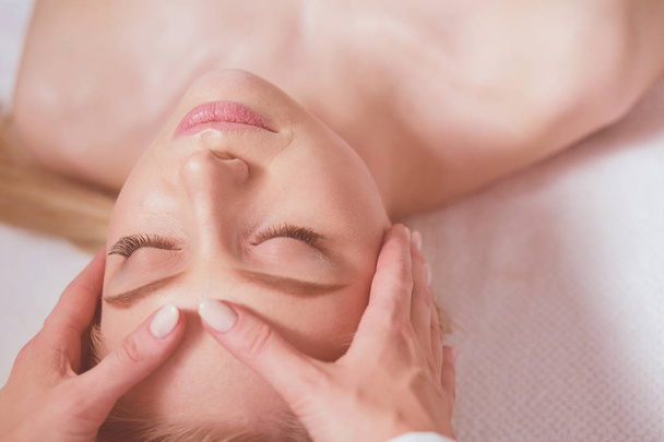 Jeune femme allongée sur une table de massage, relaxante les yeux fermés. Femme. Salon de spa - Photo, image