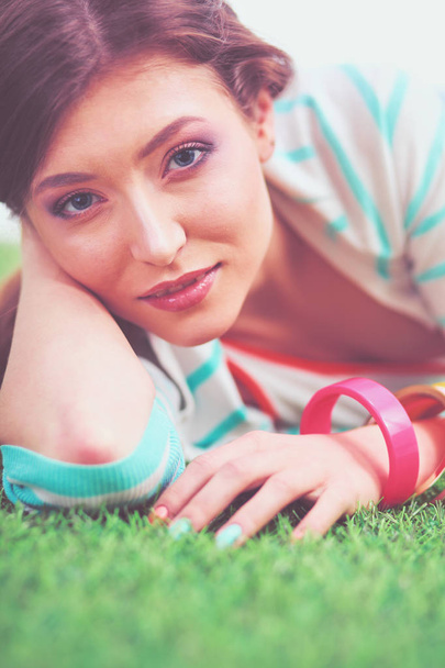 Beautiful young woman lying on the green grass - Foto, Imagen
