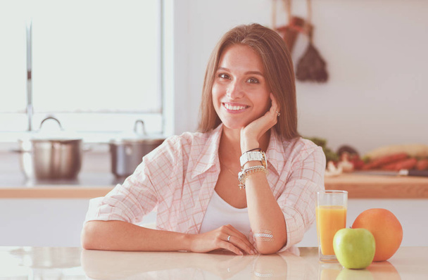 Young woman sitting a table in the kitchen. Young woman - Photo, Image
