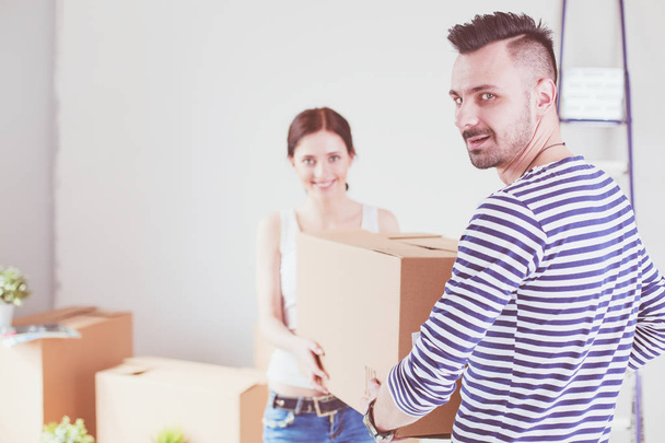Happy young couple unpacking or packing boxes and moving into a new home. young couple - Foto, imagen